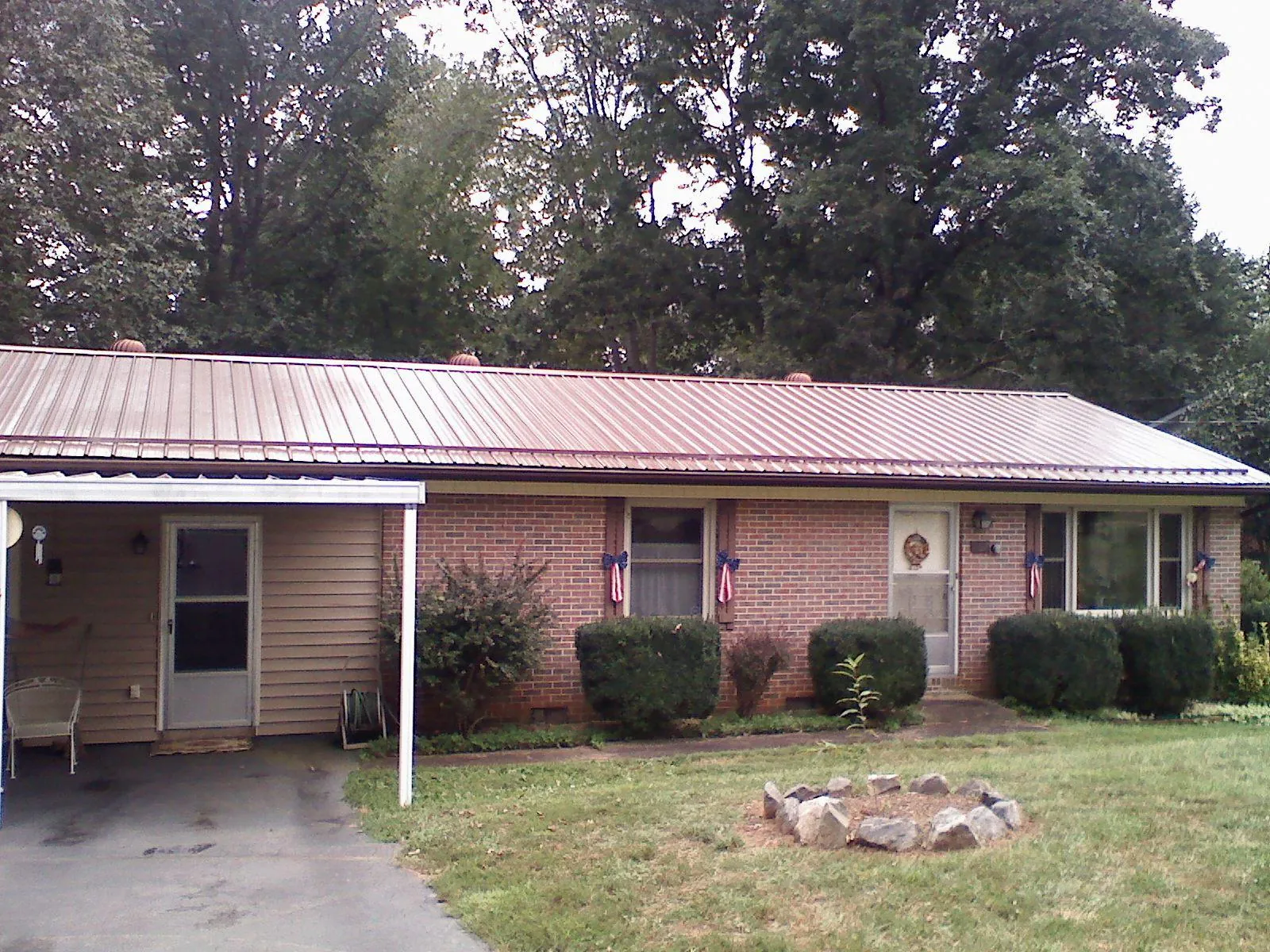 Bronze metal roof and carport on a brick ranch home — Roof Repair work by our crew in Clarksdale